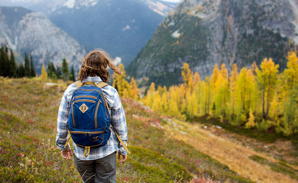 A person hiking in a mountain pass wearing a Guide's Edition Synapse 25.